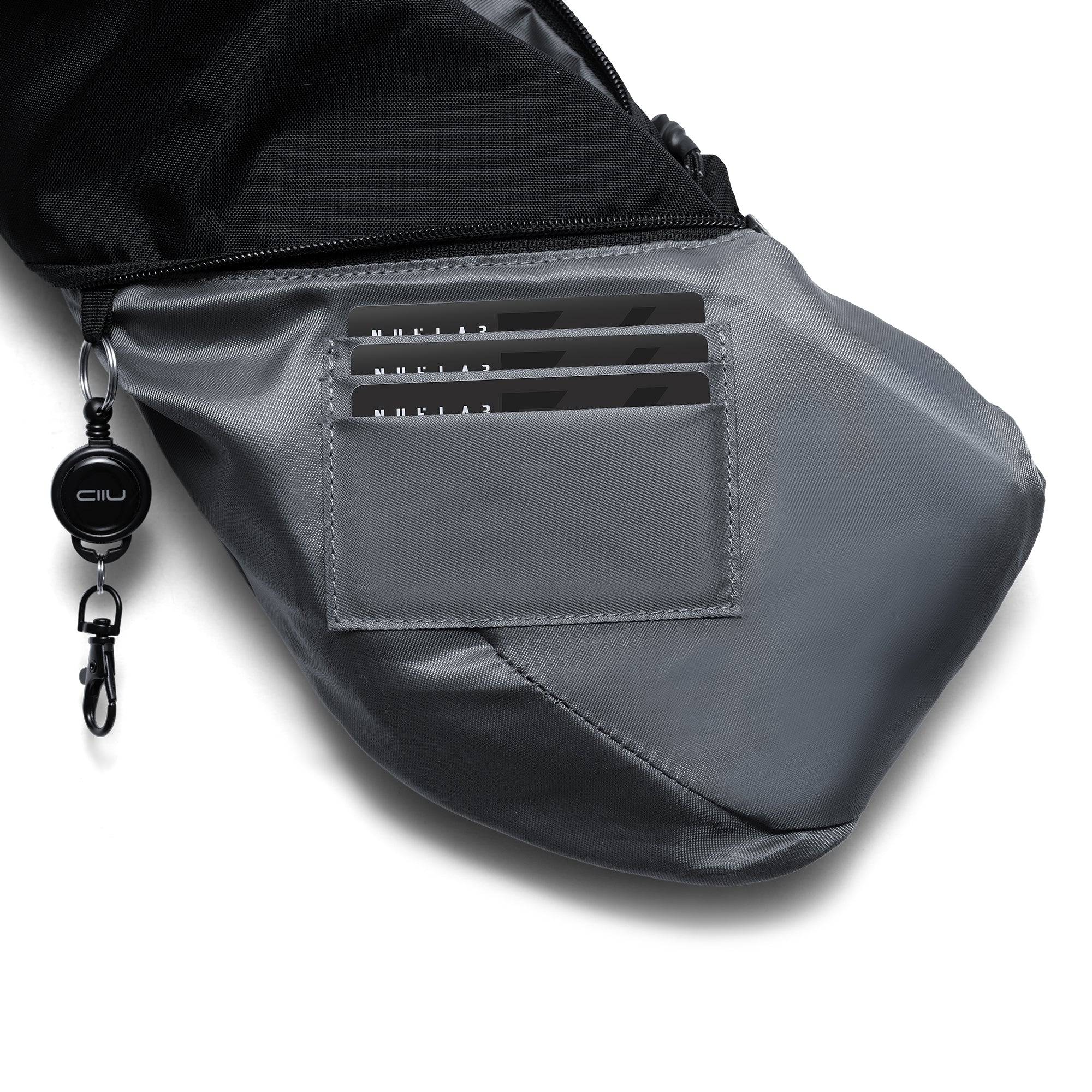 Close-up interior shot of Gray Shadow Grid FINO V Ultra-slim Tech Sling crossbody bag, built-in triple card pocket holding bank cards, detachable branded retractable key clip hook, smooth grey inner lining and waterproof exterior zipper compartment, detail showing multi-functional daily storage design on white background