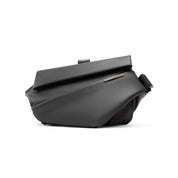 Studio front profile shot of Mid-night Black NIID R1 Radiant Urban Sling Black Label crossbody bag, matte waterproof smooth fabric, folded flap design with engraved URBANATURE metal brand plate, adjustable shoulder strap, isolated on clean white background