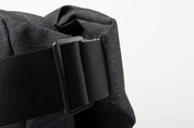 Close-up detail of black adjustable strap buckle on indigo woven NIID RO crossbody bag, thick woven shoulder strap, isolated on clean white background