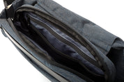Close-up shot of open Indigo NIID RO Radiant crossbody bag interior, showing multiple layered zipper pockets and smooth dark lining, spacious organized storage compartments
