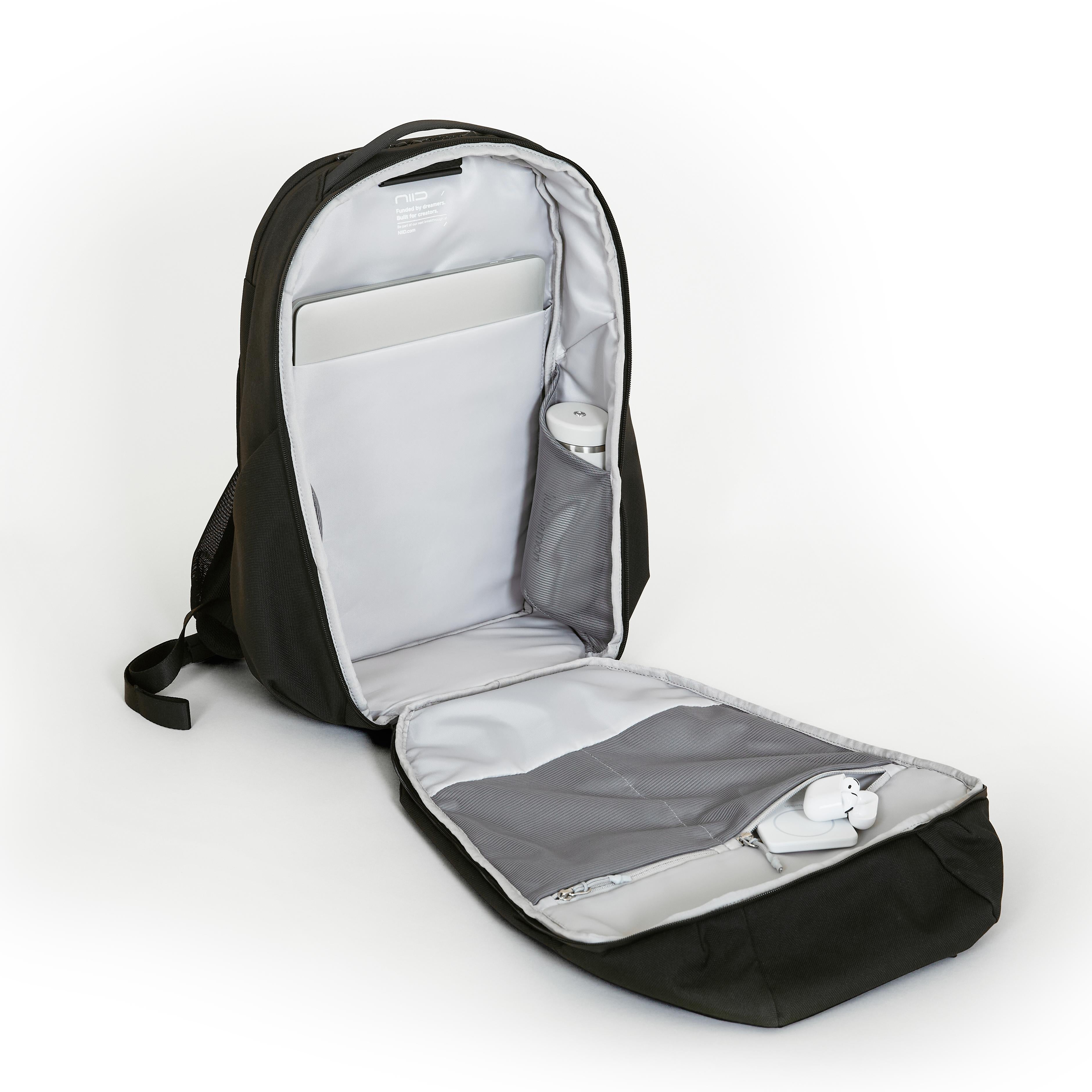 NIID NEO Nomad 30-32L Backpack N4 in Roman Black open showing laptop sleeve, water bottle pocket and front mesh pocket with earbuds and charger.