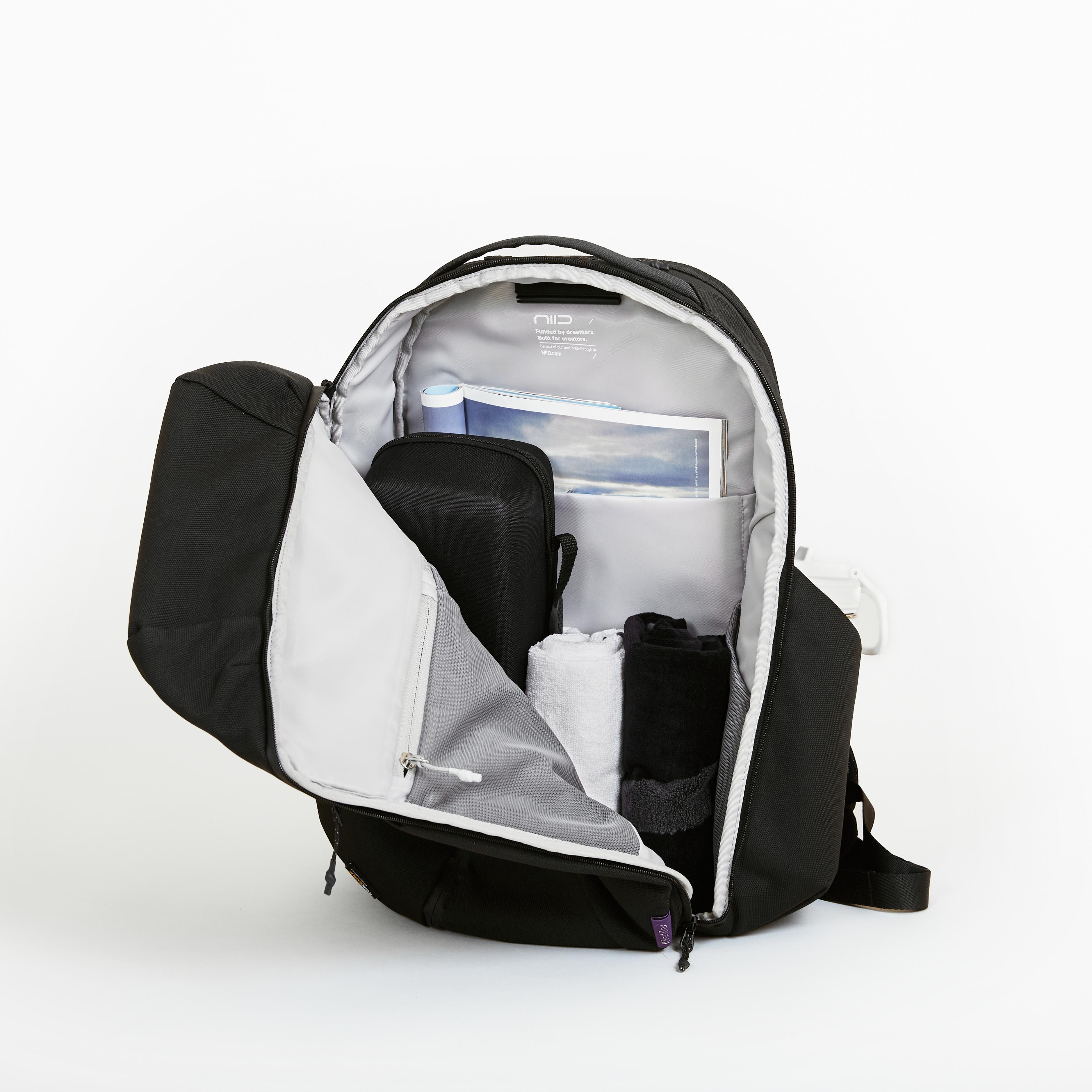 NIID NEO Nomad 30-32L Backpack N4 in Roman Black open clamshell, main compartment packed with magazine, pouch and folded clothes, travel capacity shot.