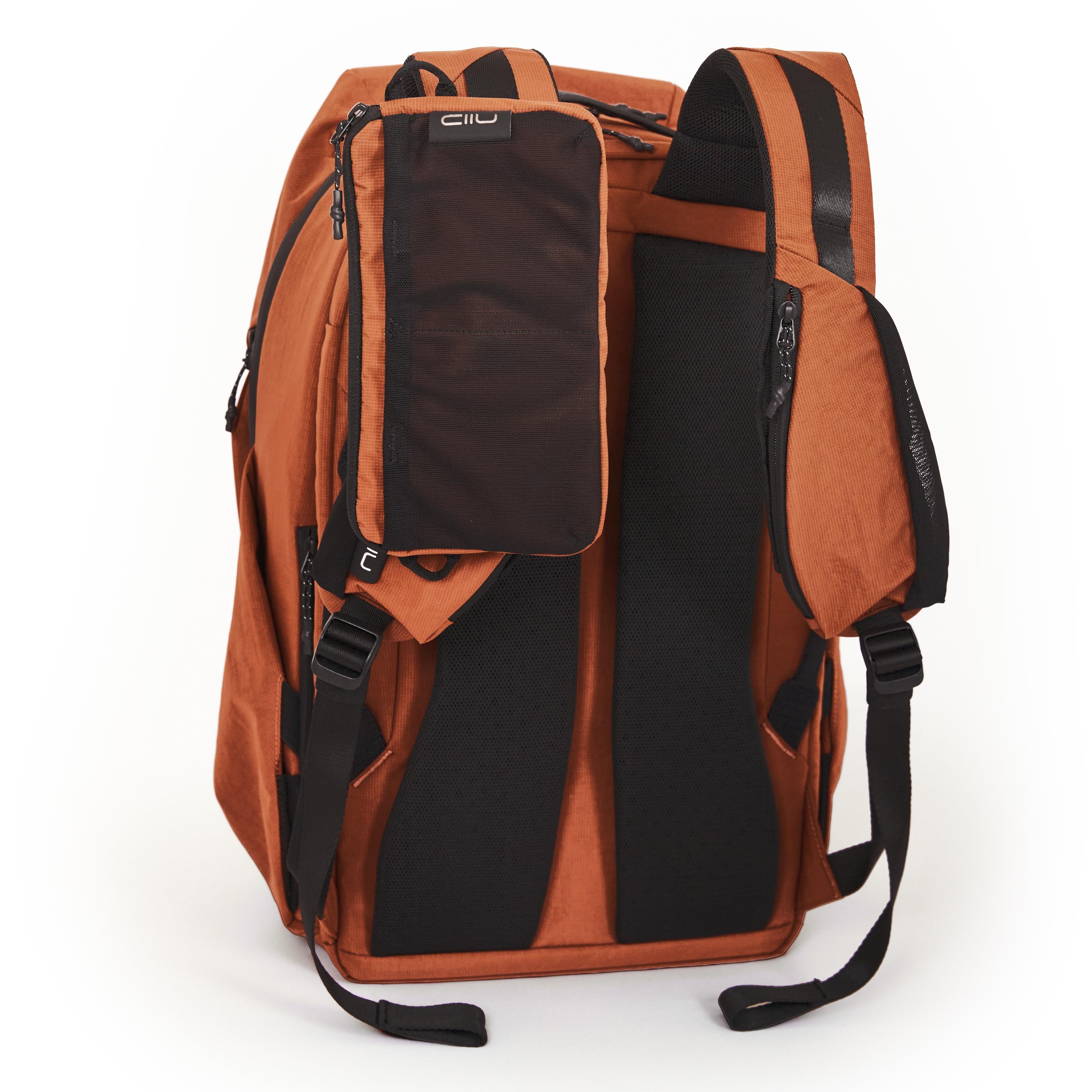 NIID NEO Nomad Backpack N4 in Venetian Red, back view showing padded shoulder straps and mesh Tech Pouch attached to strap system.
