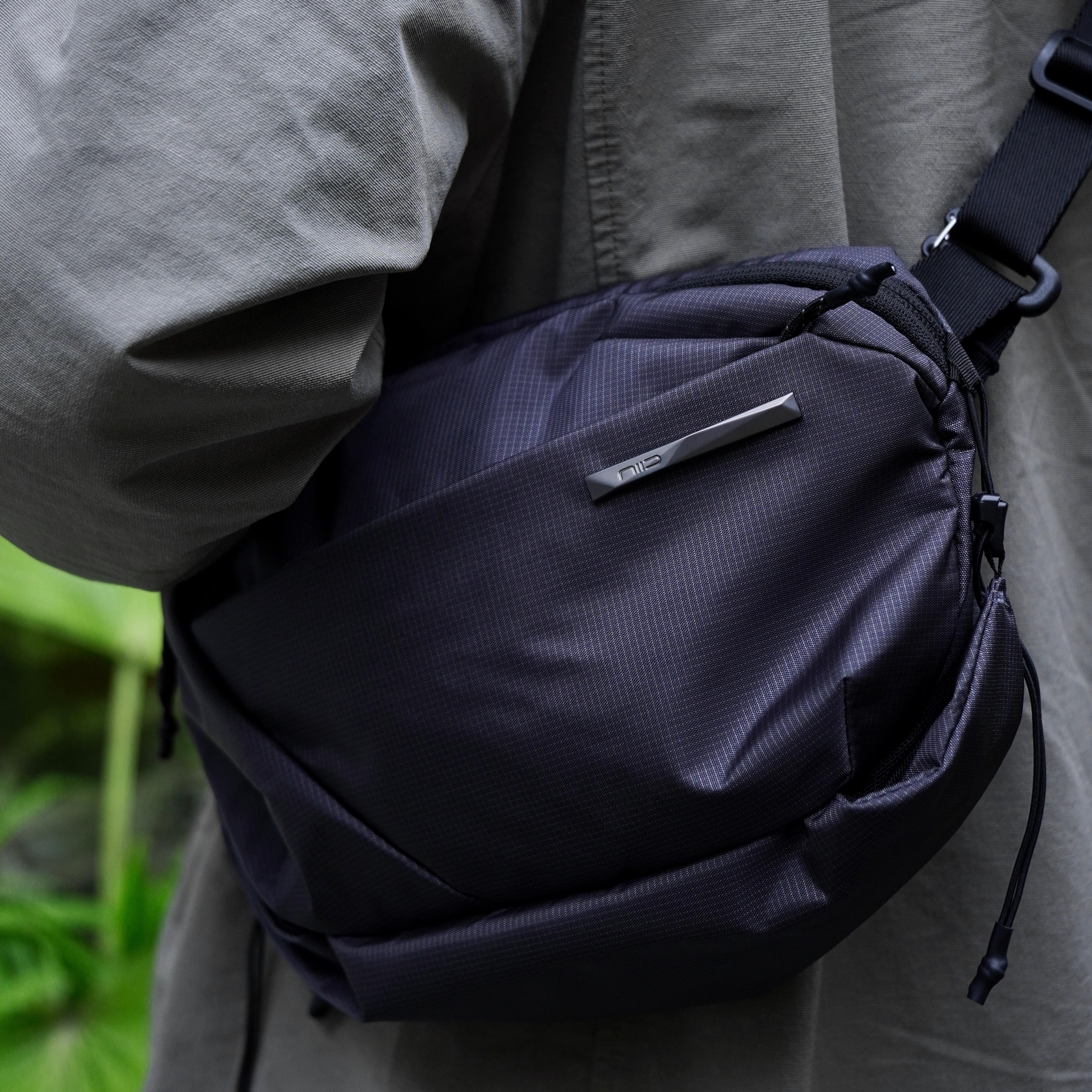 NIID NEO Nomad 4L Sling Bag‑N1 graphite gray diamond grid sling bag close‑up worn on waist, textured fabric and NIID logo detail, matched with casual jacket, outdoor EDC crossbody bag