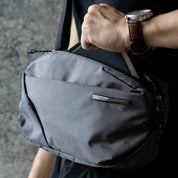 NIID NEO Nomad 4L Sling Bag‑N1 Graphite Gray unisex waterproof lightweight crossbody sling bag, close‑up view of metal NIID logo plate and grid fabric texture, 4L EDC chest bag