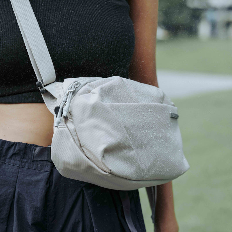 NIID NEO Nomad 4L Sling Bag‑N1 Pearly Gray unisex waterproof lightweight crossbody sling bag, outdoor water‑droplet demonstration, 4L EDC everyday chest bag