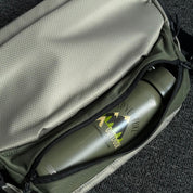 Detail shot of NIID NEO Nomad 5L Sling Bag‑N1L pearly gray, side expandable water‑bottle pocket holding outdoor tumbler, display elastic mesh side pocket design for daily commute and outdoor use.