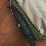 Close‑up detail of NIID NEO Nomad 5L Sling Bag‑N1L, expandable side pocket storing compact folding umbrella, mesh fabric and zipper design for rainy‑day daily commute.