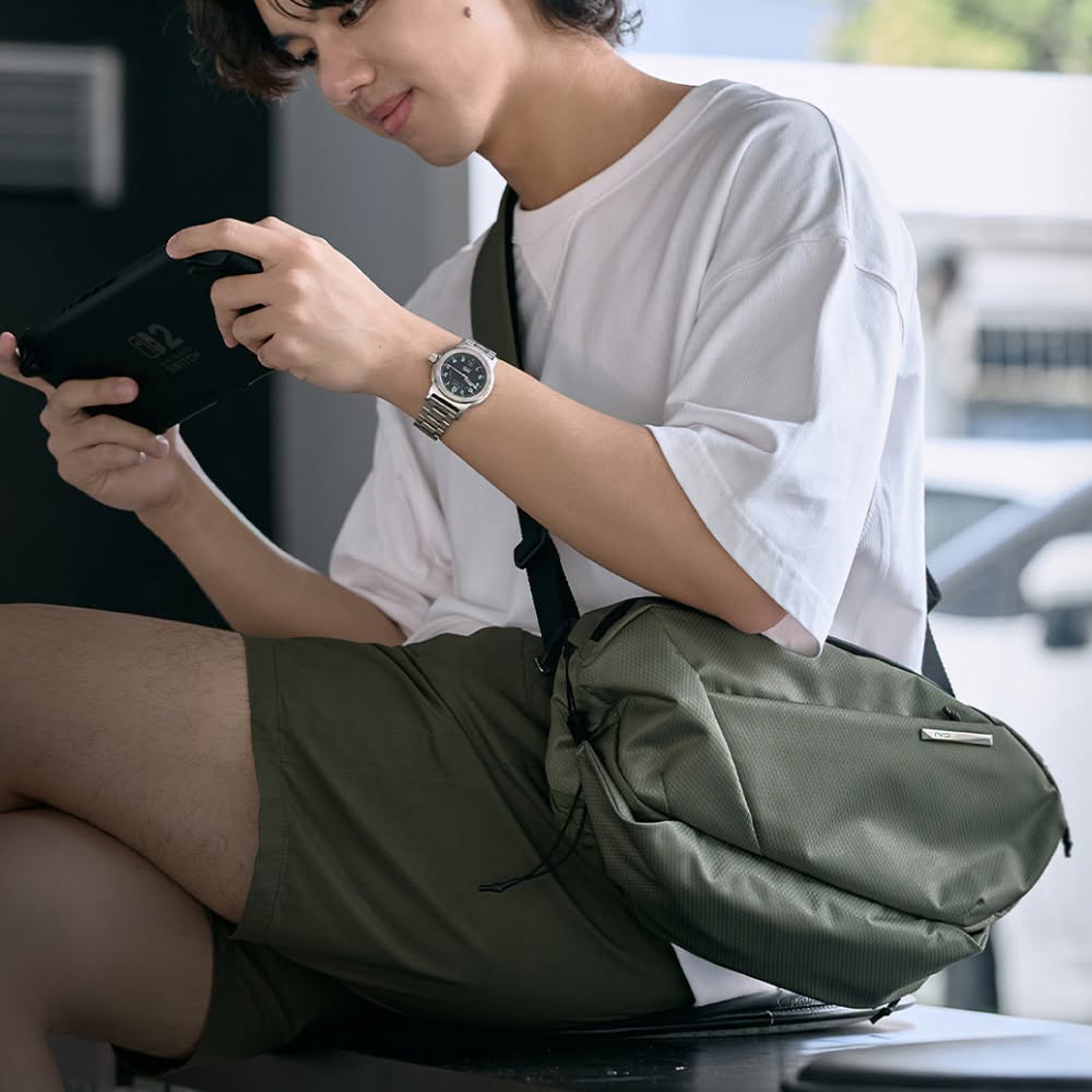 Man wearing NIID N1L dewy moss green sling crossbody bag, casual street style daily carry photo