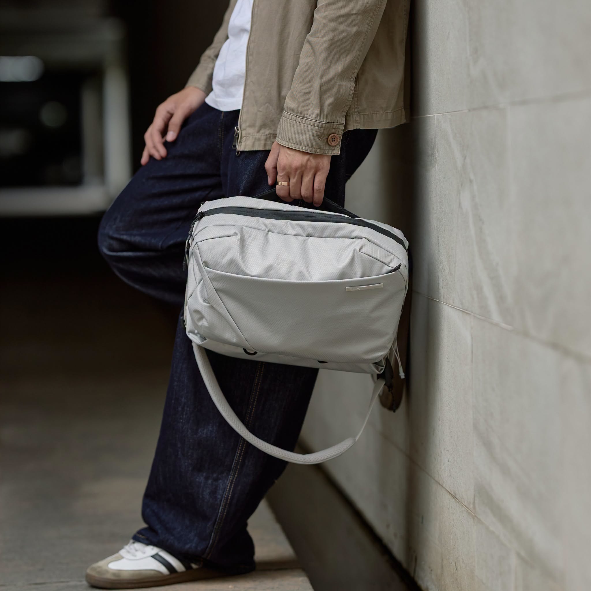 NIID N2 pearly gray sling bag held by hand, urban casual men outfit shot