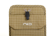Close-up of Dune Tan Nomad Pouch front flap showing NIID logo, black drawstring cord lock and fabric eyelets.