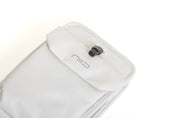Close-up of Pearly White Nomad Pouch angled front flap showing NIID logo and black drawstring cord lock.