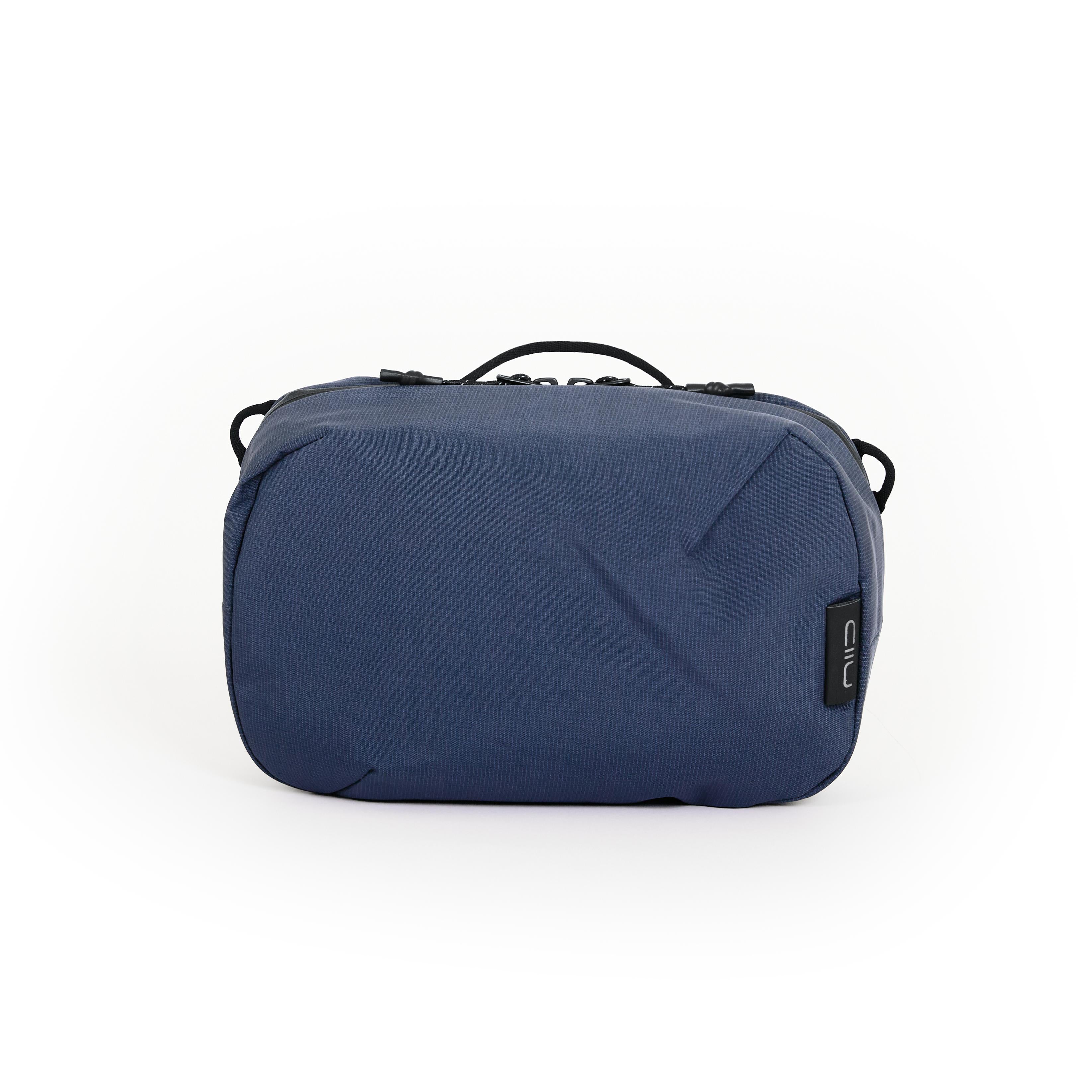 NIID NEO Tech Pouch in Prussian Blue, front view closed showing top handle, zipper pulls and side D-rings.
