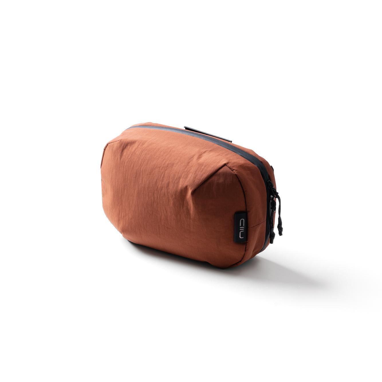 NIID NEO Tech Pouch in Venetian Red, closed side angle product shot showing zipper and NIID tag.
