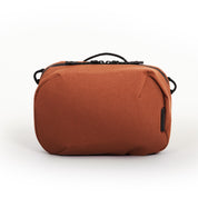 NIID NEO Tech Pouch in Venetian Red front view showing top handle, dual zipper pulls and side attachment loops.