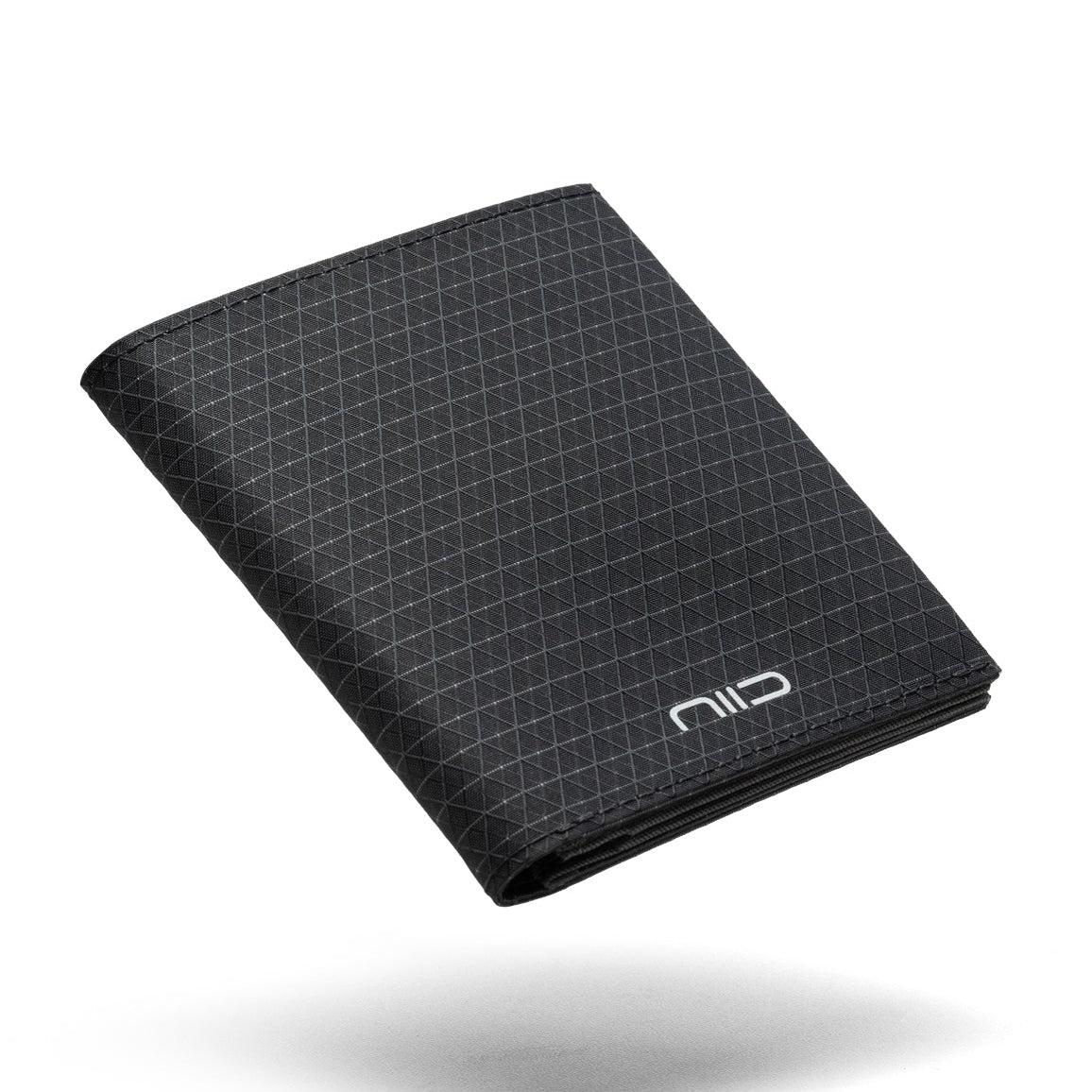 Floating shot of black Cordura fabric NIID NEX slim bifold wallet on clean white background, subtle triangular grid pattern all over surface, white embossed NIID logo on lower front, soft shadow underneath, lightweight outdoor men’s card holder product photo