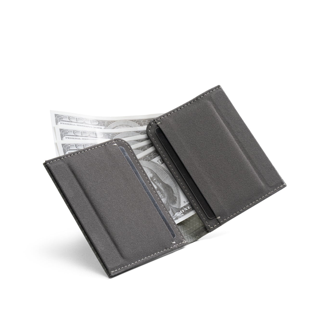 Open dark gray Nebula fabric NIID NEX slim bifold wallet on clean plain white background, layered card slots with US dollar bills stored inside, inner lightweight fabric structure display of minimalist men’s everyday carry card wallet