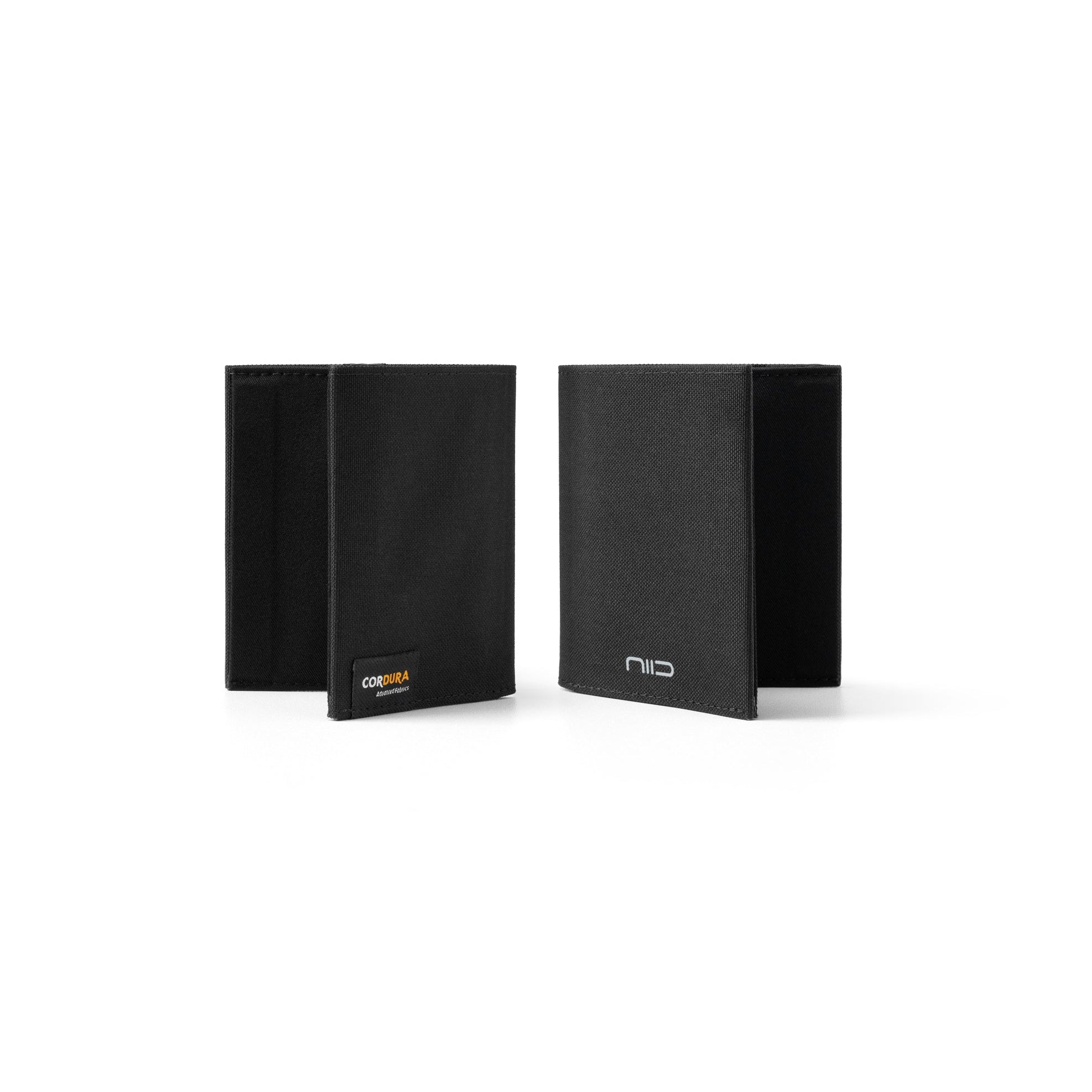 Side-by-side studio shot of two solid black Cordura fabric NIID NEX slim bifold wallets on clean white background; left one closed with orange Cordura woven label, right one half-open showing inner fabric and silver NIID embossed logo, minimalist wear-resistant men’s EDC wallet comparison product photo