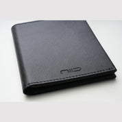 Close‑up shot of black smooth genuine leather NIID NEX Slim Wallet, embossed NIID logo, minimalist bifold men's card wallet