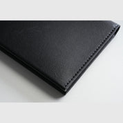 Close‑up detail shot of black smooth‑leather NIID NEX Slim Wallet, fine edge stitching texture, premium men bifold wallet