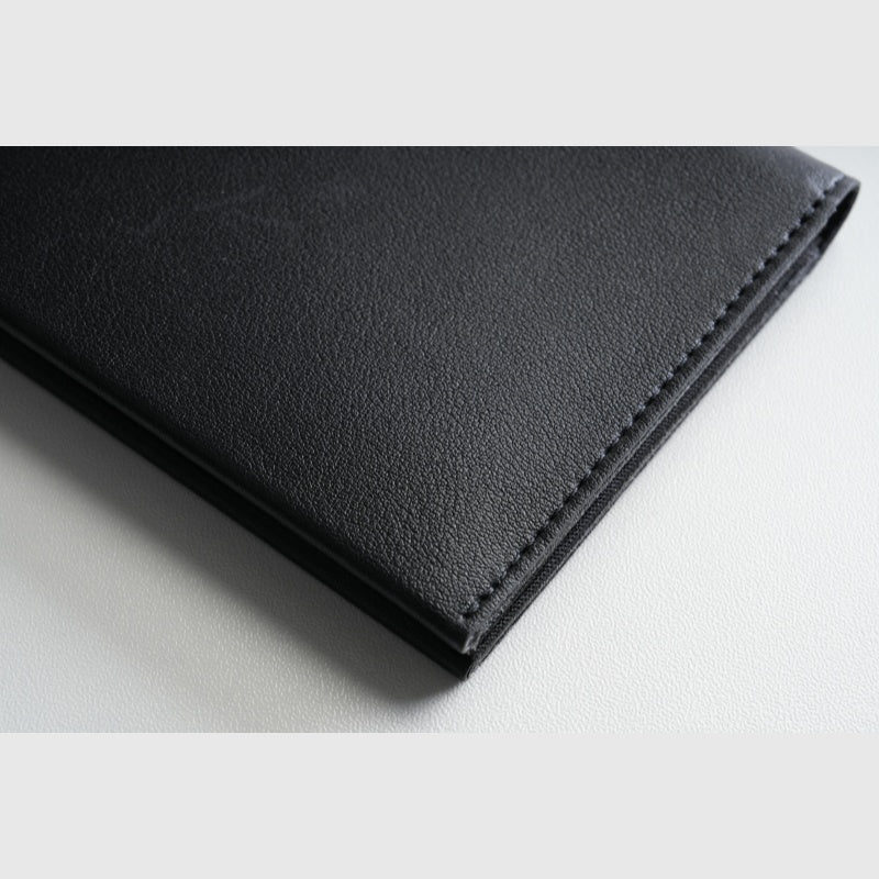 Close‑up detail shot of black smooth‑leather NIID NEX Slim Wallet, fine edge stitching texture, premium men bifold wallet
