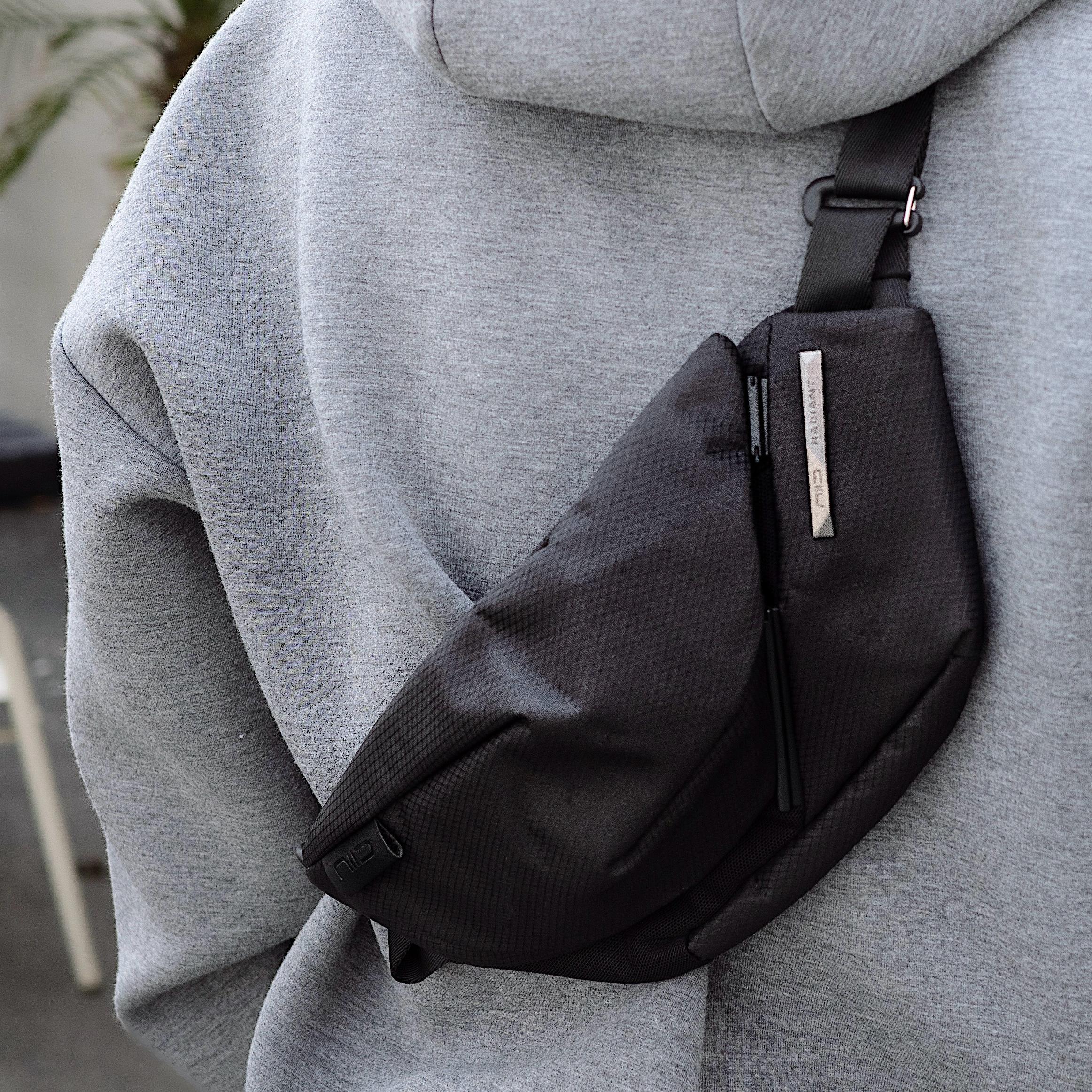 NIID Radiant R2 Everyday Sling Bag Diamond Grid Black, real‑buyer chest wearing close‑up shot, modular EDC crossbody sling bag with silver brand tag.