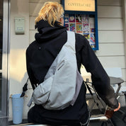 Real‑customer outdoor lifestyle shot of NIID Radiant R2 modular everyday sling bag in Diamond Grid Gray, cross‑back carry beside city coffee shop. Displays practical real‑life silhouette, ideal for urban hangouts, daily commuting and casual city travel.