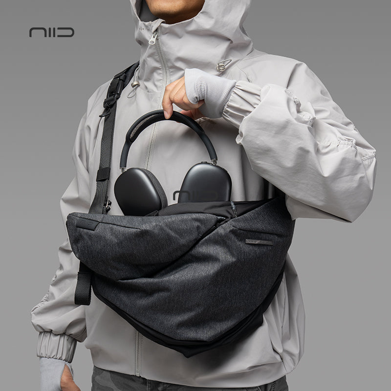 NIID Radiant R2 Everyday Sling Bag Gray Shadow Grid modular crossbody sling bag, man carrying bag with over‑ear headphones inside, urban EDC tech sling