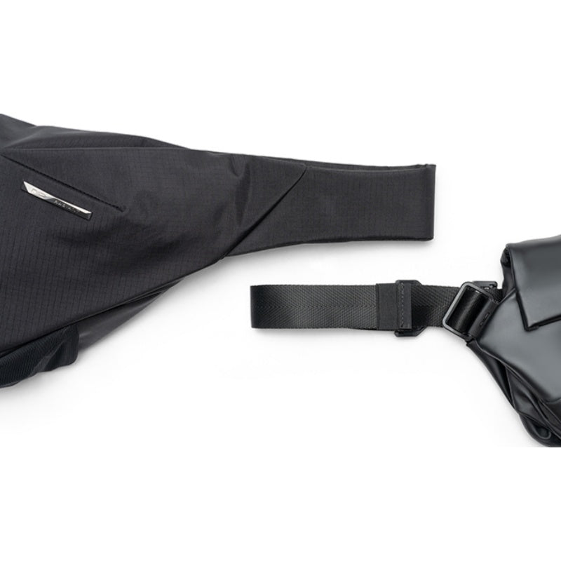 Close-up shot of black NIID Radiant II crossbody sling bag fabric, adjustable shoulder strap and quick-release buckle on clean white background, textured waterproof material detail display