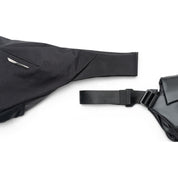 Close-up shot of black NIID Radiant II crossbody sling bag fabric, adjustable shoulder strap and quick-release buckle on clean white background, textured waterproof material detail display
