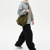 Male model with NIID VIA Gym‑Bag olive green shoulder tote bag, plain white studio background