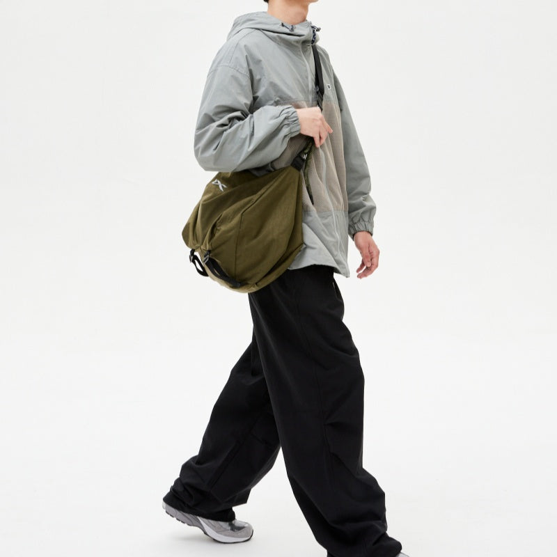 Male model with NIID VIA Gym‑Bag olive green shoulder tote bag, plain white studio background