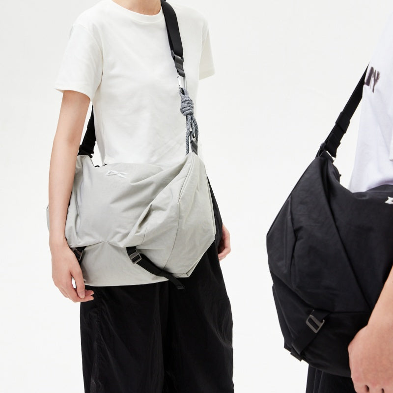 Two‑person display for NIID VIA Gym Bag of light‑grey and black colourway, minimalist white studio background