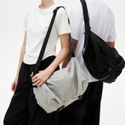 Two‑model display of NIID VIA Gym Bag in black and light‑grey on plain white studio background