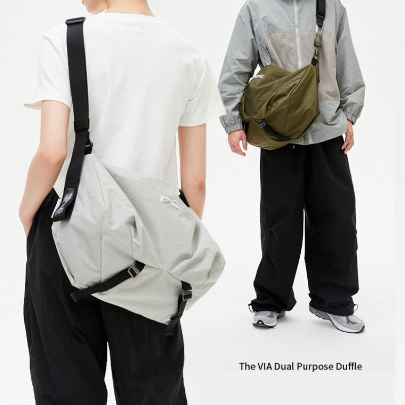 Two‑model showcase for NIID VIA Gym Bag in light‑grey and olive‑green, white plain studio backdrop