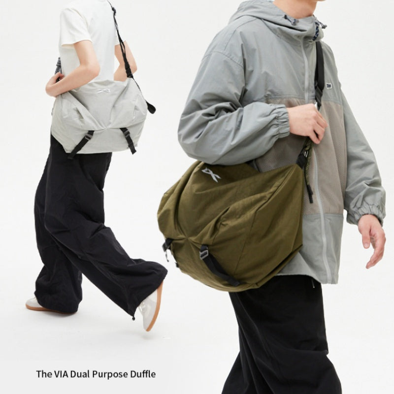 Two‑model display of NIID VIA Gym Bag in olive‑green and light‑grey, white studio background