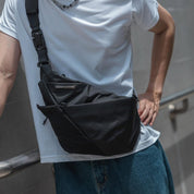 Front view of the sleek black NIID FINO V F5 sling bag worn across the chest, emphasizing its minimalist ergonomic profile and close-to-body anti-theft security for urban professionals and digital nomads.