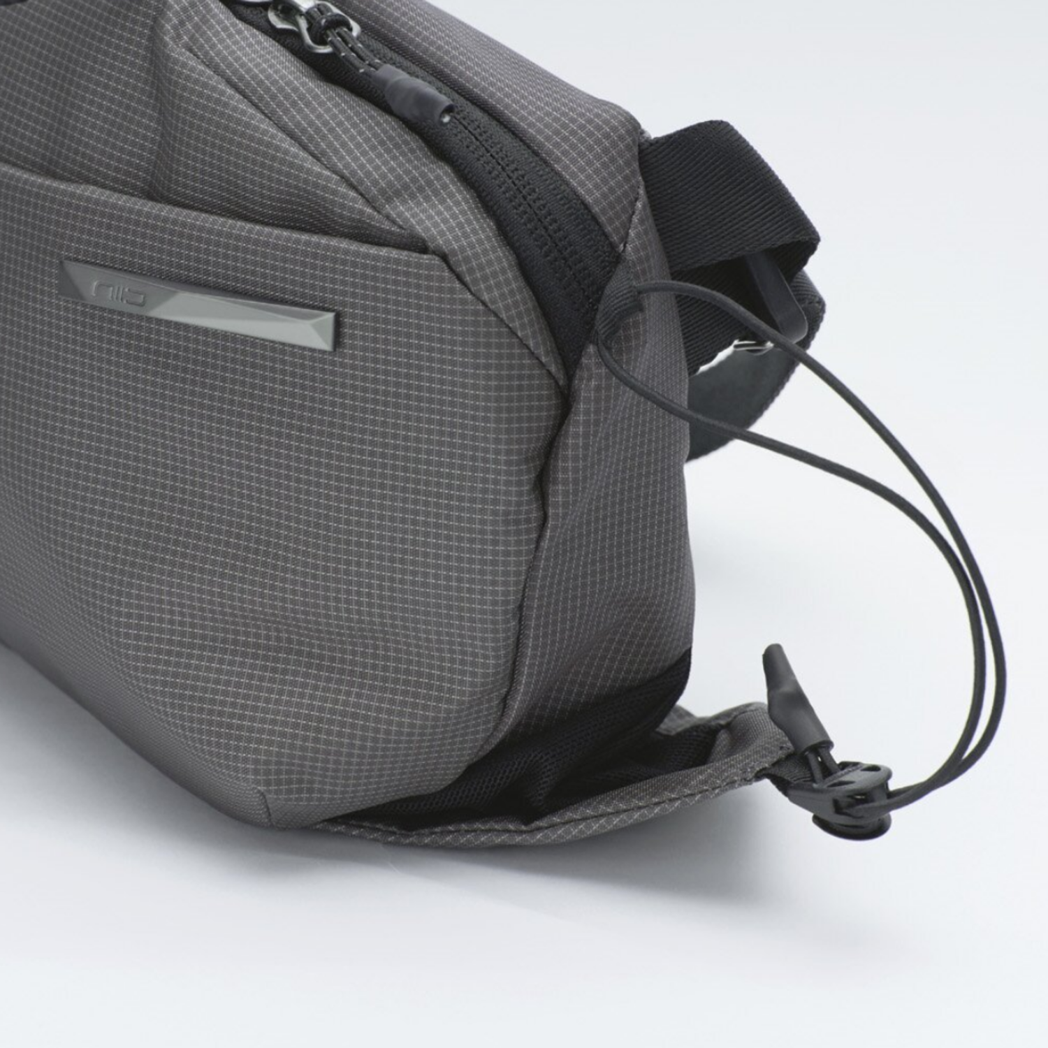 Side elastic drawstring detail of NIID N1 sling bag, expandable pocket to hold small items like keys and earphones.