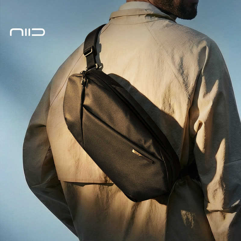 NIID N1L unisex crossbody bag in DIAMOND GRID BLACK worn by a model, showcasing its ergonomic fit, sleek urban style, and comfortable everyday carry experience.
