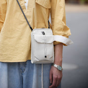 A model wearing the NIID NEO Nomad Pouch in Pearly Gray as a stylish crossbody bag, perfect for everyday urban lifestyle and travel.