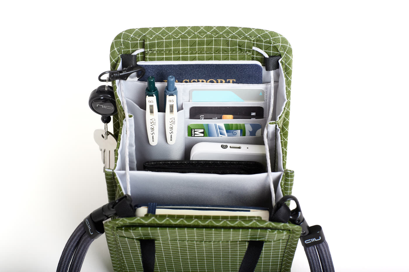 NIID NEO Nomad Pouch in Pine Green showing its full storage capacity, perfectly organizing travel essentials like a wallet, notebook, and power bank.