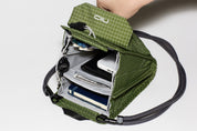 Detailed interior view of the NIID NEO Nomad Pouch in Pine Green, featuring organized slots for a passport, credit cards, pens, and smartphone.