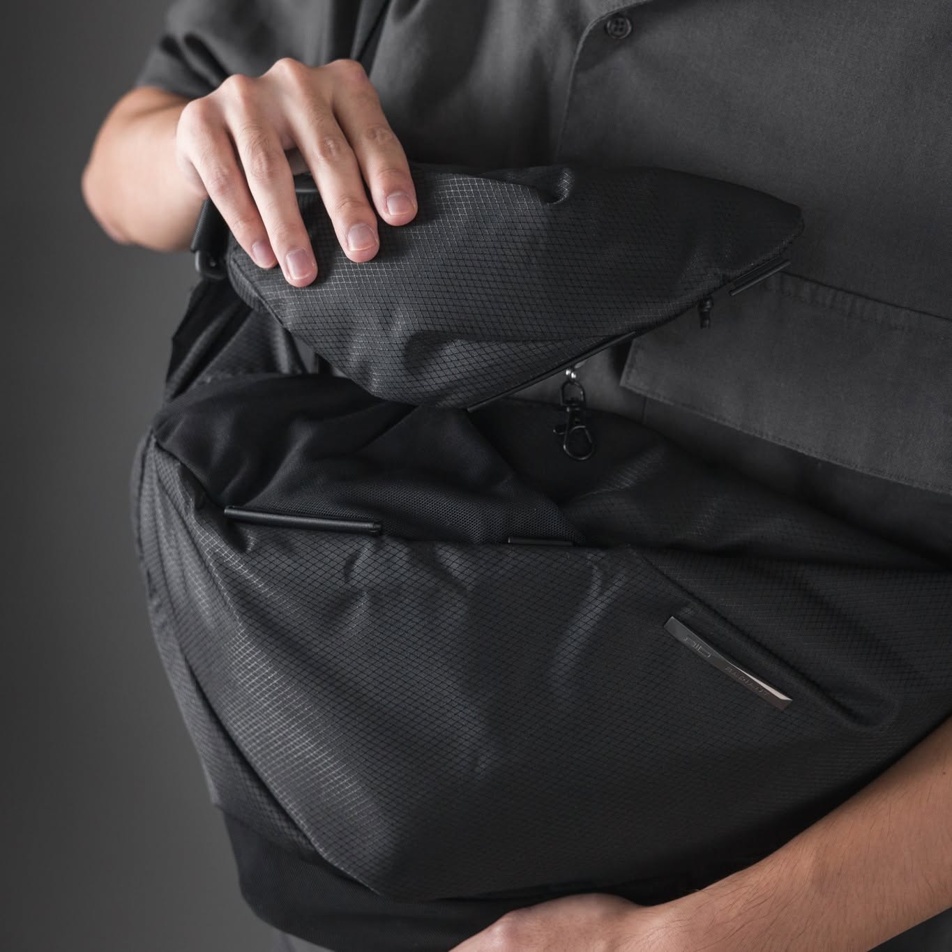 Close up of the NIID Radiant R2 techwear sling bag featuring the Glide-Track system, demonstrating how any two pieces within the modular combo ecosystem seamlessly slide and couple together for elite workplace mobility.