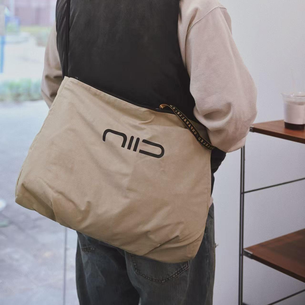 NIID S7 Statement Reversible Tote Bag in Khaki and Olive - Shoulder Lifestyle Wearing Shot with Bold Logo Display for Daily Commute
