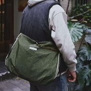 NIID S7 Statement Reversible Tote Bag in Olive and Khaki - Rear View Lifestyle Wearing Shot with Green Plants Background for Daily Urban Travel