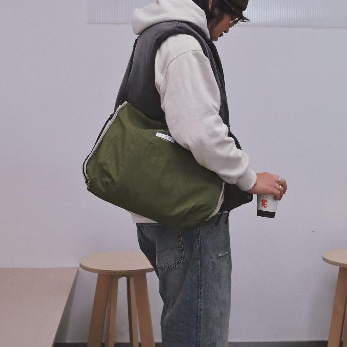 NIID S7 Statement Reversible Tote Bag in Olive and Khaki - Side-View Lifestyle Wearing Shot in Minimalist Indoor Setting for Daily Urban Commute