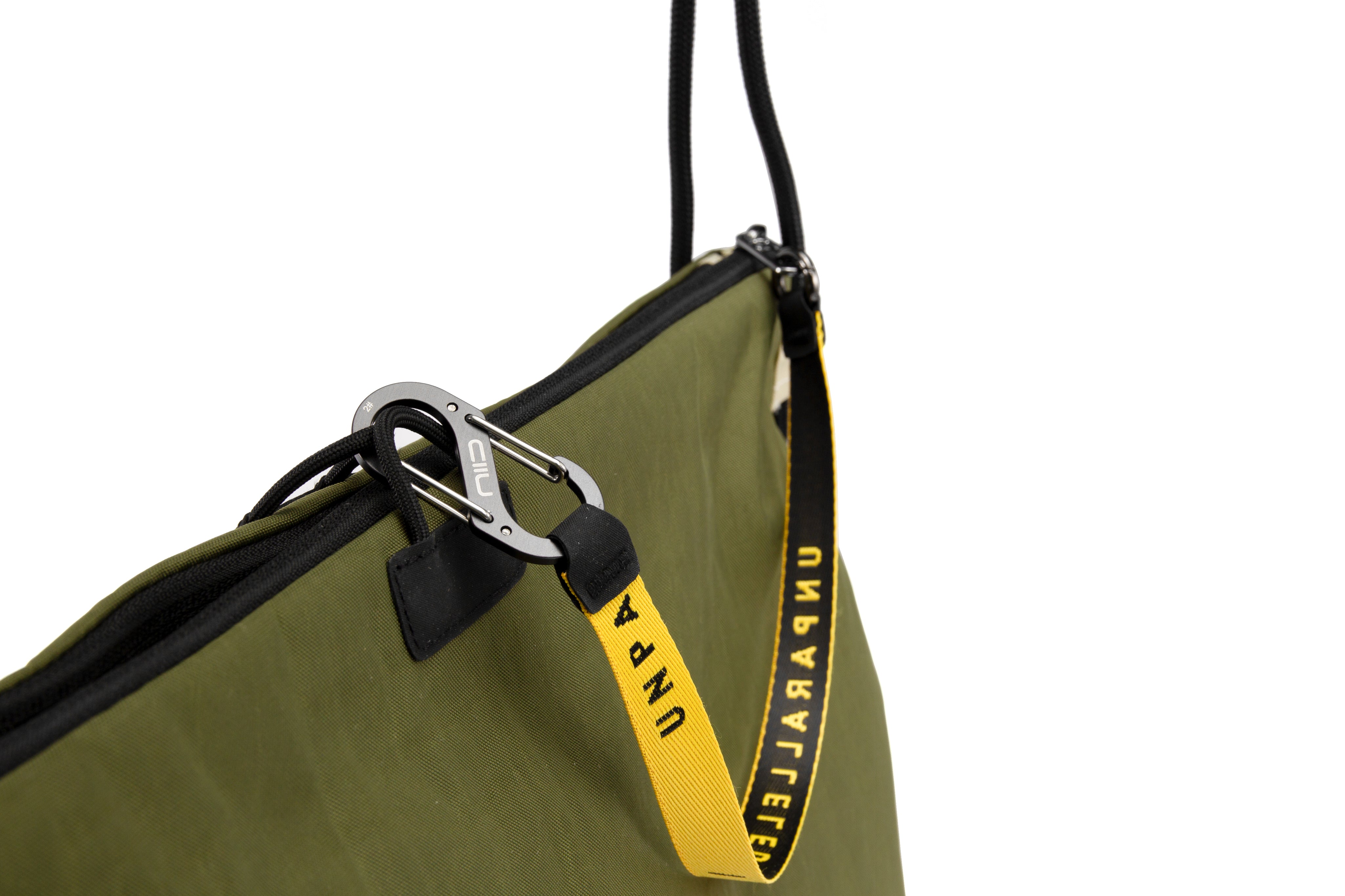 NIID ST@TEMENT S7 Tote Bag Khaki/Olive close-up of branded yellow webbing strap and metal carabiner hardware, premium accessory detail shot on white background.