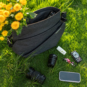 NIID R1 Radiant Mega gray messenger sling bag outdoor grass flat‑lay, matched with camera lenses, smartphone and yellow rose bouquet, photographer lifestyle scene